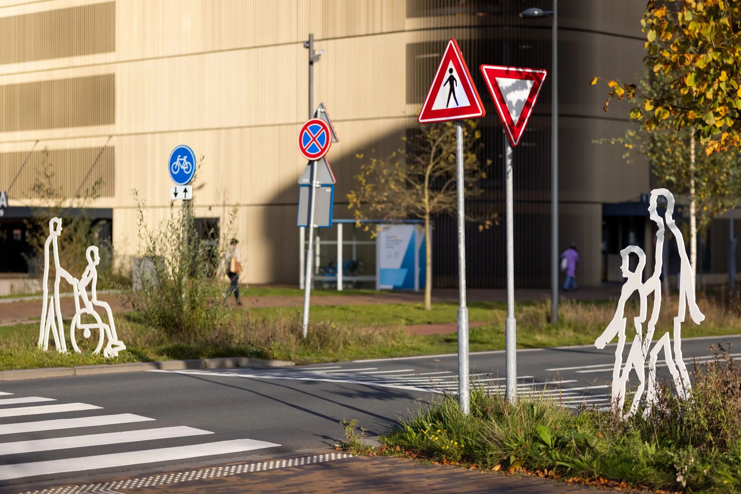 Straatbeeld in Breda met meerdere witte stalen figuren langs de rijbaan