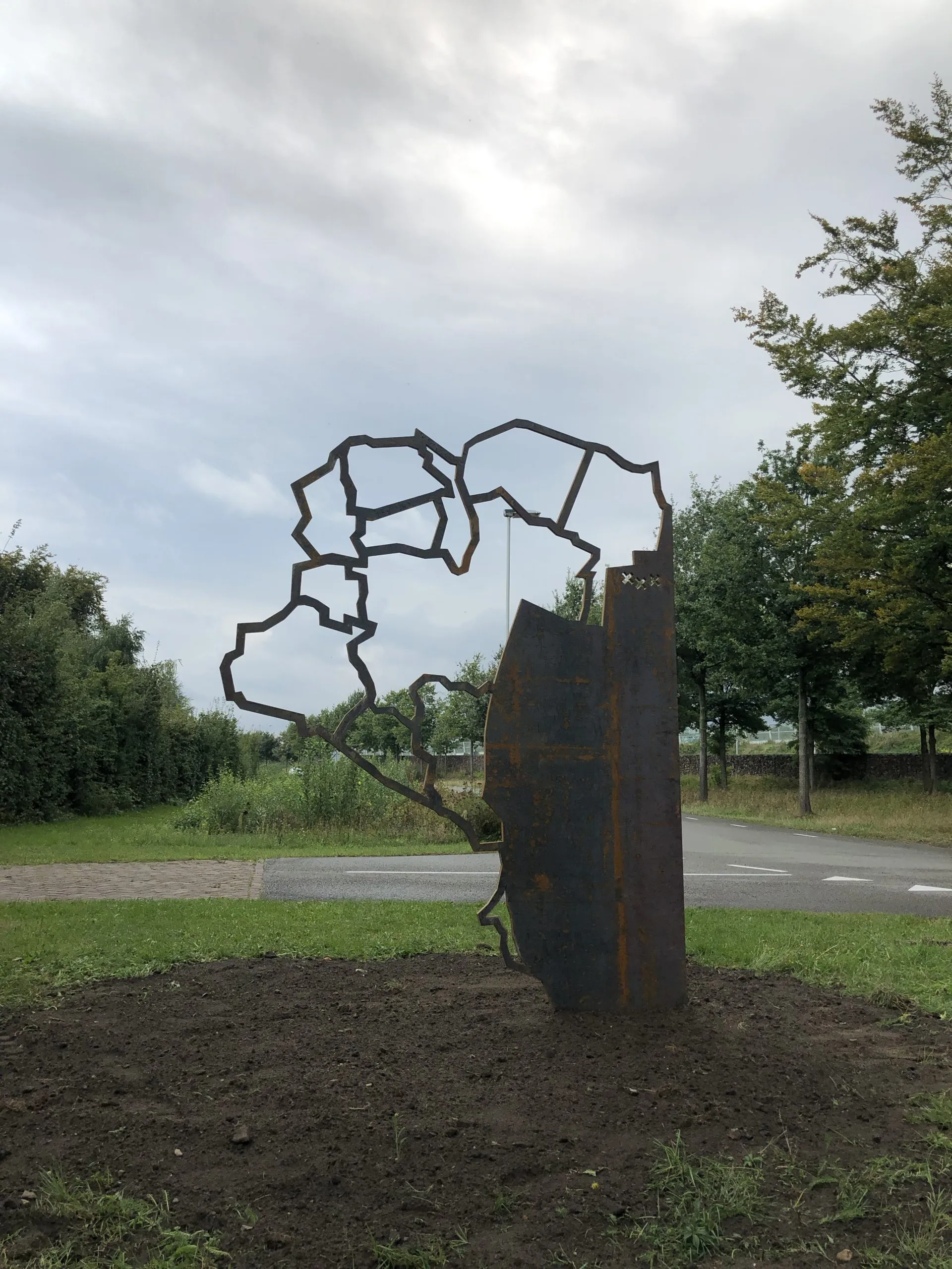 Sculptuur van cortenstaal met de contour van het buitengebied de Rith, in de berm langs de weg