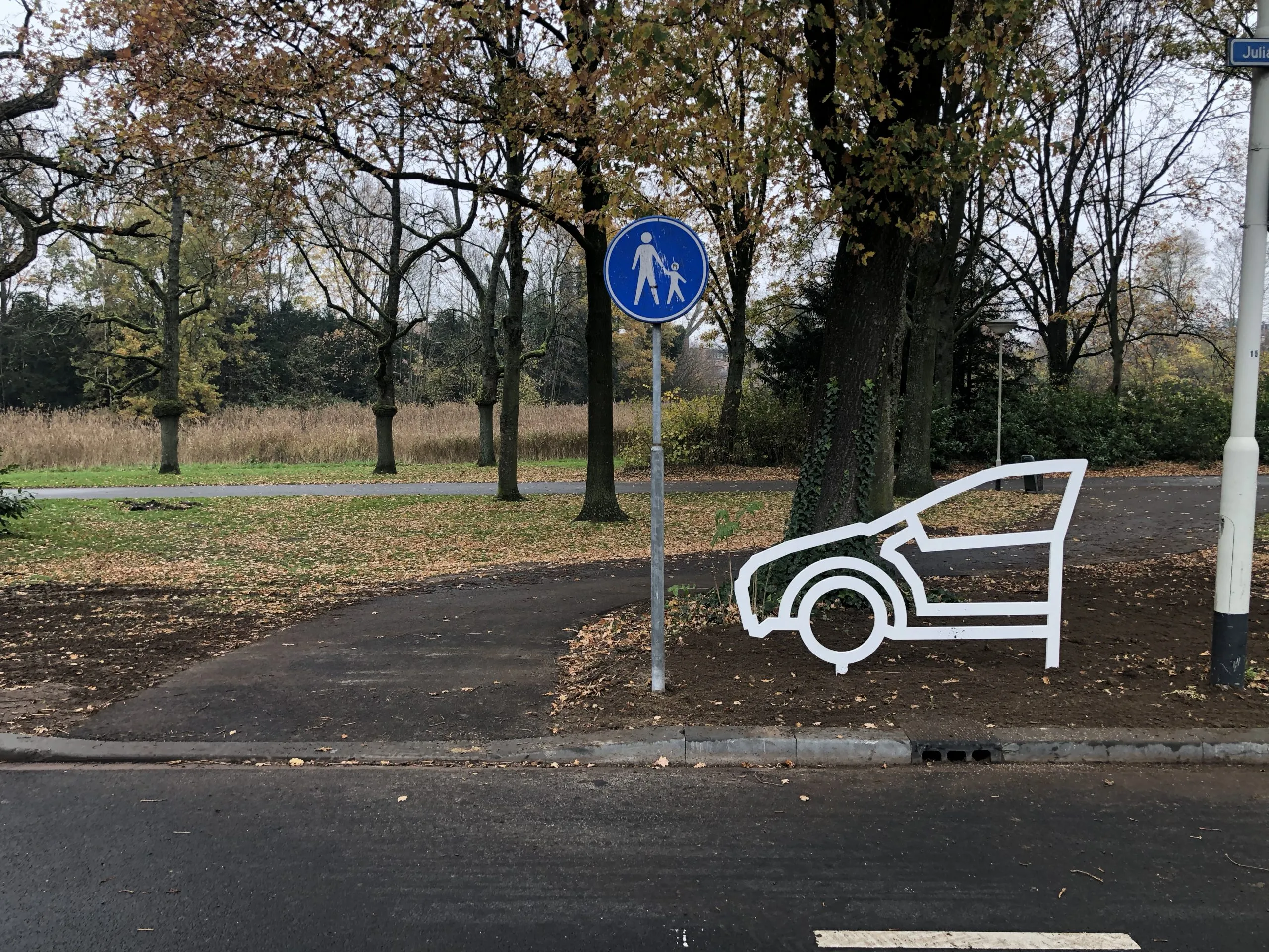 Wit stalen figuur met de tekst attentie, geen oversteek aan de Julianalaan in Breda